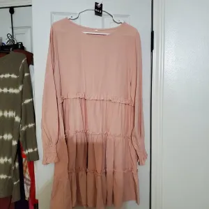 Peach dress with long sleeves and three tiered ruffles